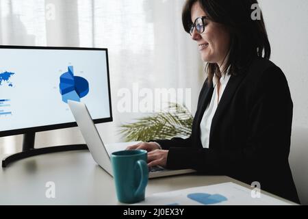 Hispanische Geschäftsfrau, die in der Bank mit einem Computer-Laptop arbeitet - Fokus auf das Gesicht Stockfoto