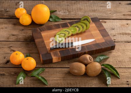 Obst mit Messer auf Holzschneidebrett Stockfoto