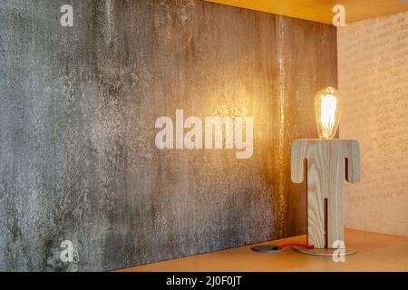 Fragment einer Studie mit einem Holztisch und einer Lampe Stockfoto