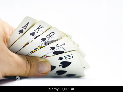 Ein Spieler enthüllt einen königlichen Flush in Pik. Glücksspiel und Glück. Stockfoto