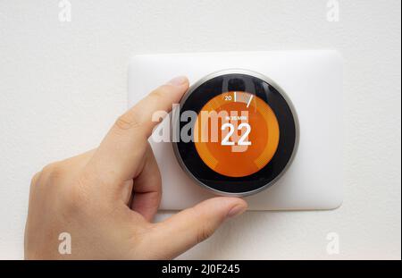 Smart Thermostat mit einer Person Aufwärmen der Raumtemperatur mit einem weichen Schatten Stockfoto