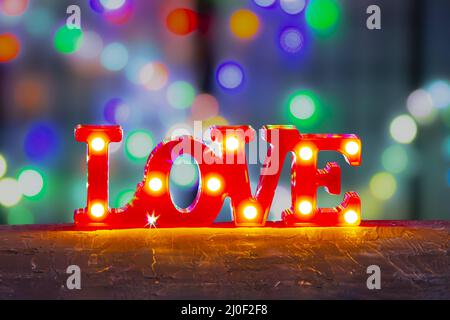 Einrichtung mit "Love Sign Bedroom"-Leuchten mit LED-Marquee Letters in Rot und farbenfrohem Hintergrund. Stockfoto