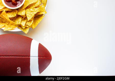 American Football mit organischen Nacho-Chips und milden Salsa auf der Seite auf weißem Hintergrund Stockfoto