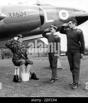 Ein Bild aus einer Serie humorvoller Neuheitenbilder, aufgenommen vom Sunday People Photografen Dennis Hutchinson - ein Offizier, der seine Füße unter einem Gloster Javelin einweicht, erhält einen Gruß. Circa: 1980 Stockfoto