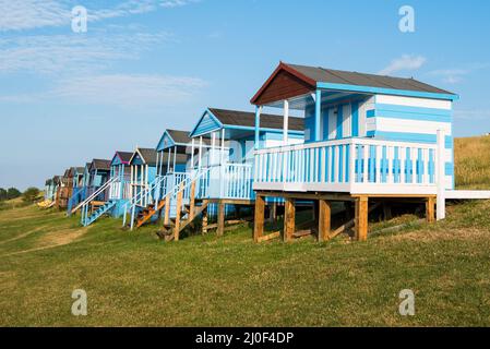 Farbenfrohe Strandhütten aus Holz mit Blick auf den Ozean an der Whitstable Coast, im Distrikt Kent, England. Stockfoto