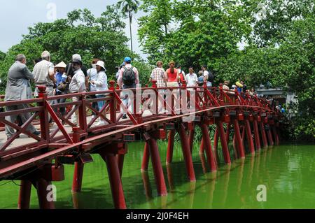 Menschen, die auf der roten Brücke von Huc zur Jade-Insel wandern. Hanoi, Vietnam Stockfoto