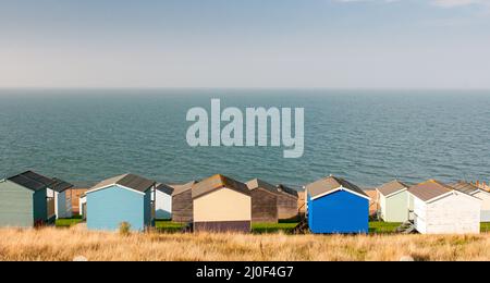Bunte Urlaub hölzerne Strandhütten mit Blick auf das Meer. Whitstable in Kent, Großbritannien Stockfoto
