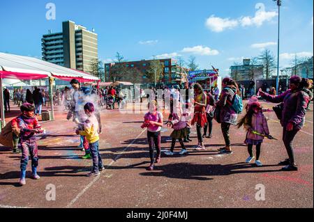 Den Haag, Niederlande. 18. März 2022. Kinder haben beim Holi-Festival in Den Haag das Spielen und Spaß mit farbigen Pulvern gesehen. Den Haag, mit der größten indischen Bevölkerung, traf sich im multikulturellen Transvaal Park, um das jährliche Holi Hangámá Festival zu feiern, auch bekannt als das Festival der Farben, was die Feier der Ankunft des Frühlings, einen neuen Anfang und den Triumph des Göttlichen und des Guten bedeutet. Das diesjährige Holi-Festival ist das Thema „Liberation“. Kredit: SOPA Images Limited/Alamy Live Nachrichten Stockfoto