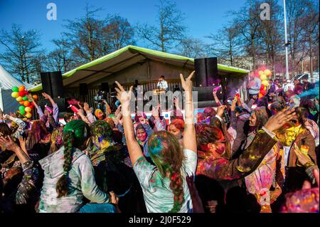 Den Haag, Niederlande. 18. März 2022. Während des Holi Festiva in Den Haag singen und tanzen die Menschen zu indischer Musik, während sie mit bunten Pulvern bedeckt sind. Den Haag, mit der größten indischen Bevölkerung, traf sich im multikulturellen Transvaal Park, um das jährliche Holi Hangámá Festival zu feiern, auch bekannt als das Festival der Farben, was die Feier der Ankunft des Frühlings, einen neuen Anfang und den Triumph des Göttlichen und des Guten bedeutet. Das diesjährige Holi-Festival ist das Thema „Liberation“. (Foto: Ana Fernandez/SOPA Images/Sipa USA) Quelle: SIPA USA/Alamy Live News Stockfoto