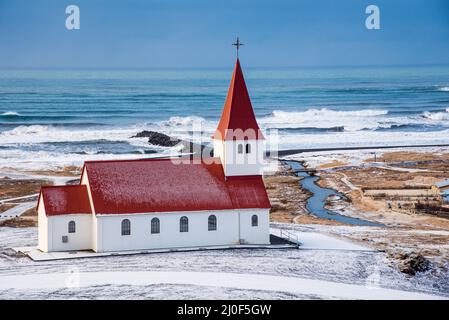 Die Kirche Vik i Myrdal auf dem Gipfel des Hügels bietet malerische Bilder des atlantischen Ozeans an Stockfoto