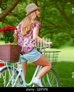 Machen Sie eine gemütliche Fahrt. Aufnahme einer jungen Frau, die im Park unterwegs ist. Stockfoto