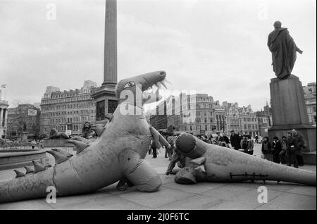 Auf dem Londoner Trafalgar Square kämpfen sich zwei Dinosaurier, die so hoch wie ein Doppeldeckerbus sind. Die Veranstaltung soll die Boys and Girls Exhibition bekannt geben, die am 10.. märz im Alexandra Palace eröffnet wird. Die riesigen lebensgroßen Monster kämpfen im tödlichen Kampf auf der Ausstellung. 6.. März 1979. Stockfoto