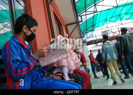 Menschen mit Schutzmasken warten vor einem Krankenhaus auf die Untersuchung des Coronavirus Covi Stockfoto