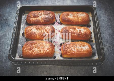 Köstliche heiße hausgemachte Brötchen gefüllt mit Heidelbeere auf einem Backblech Stockfoto