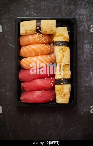 Nigiri Sushi-Set in Plastikbehälter bereit für die Lieferung zum Mitnehmen. Nahaufnahme der Lunchbox zum Mitnehmen Stockfoto