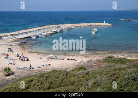 Fischerhafen mit Menschen am Strand und Schwimmen. Akamas-Halbinsel, zypern Stockfoto