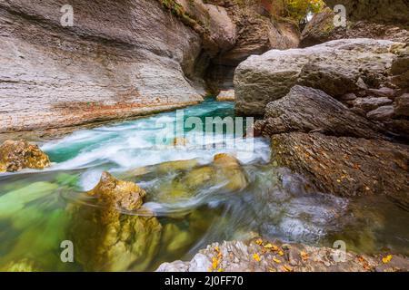 Der rasante Fluss des smaragdgrünen Bergflusses in der Steinschlucht am Herbstmorgen Stockfoto