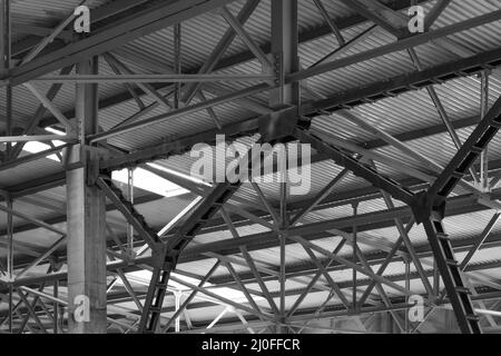 Metallrahmen des Daches der Industrieanlagen im Unternehmen Innenansicht in schwarz-weiß Stockfoto