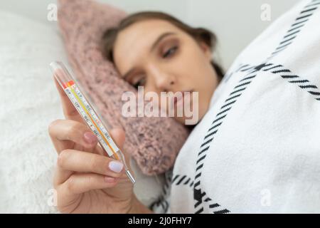 Der Teenager überprüfte ihre Temperatur und stellte fest, dass ihr Fieber hoch war. Stockfoto