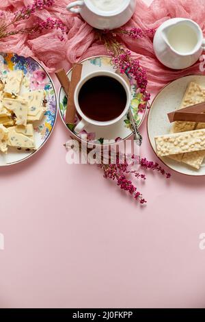 Heiße Schokolade oder Kakao in Tasse mit verschiedenen Süßigkeiten an den Seiten. Weiße Schokoriegel und Kekse Stockfoto