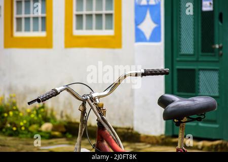 Altes Fahrrad hielt vor den Häusern im Kolonialstil Stockfoto