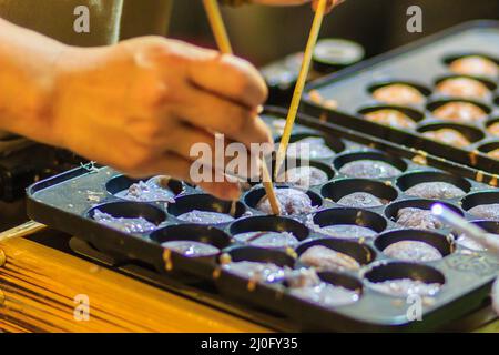 Anbieter ist das Kochen für Khanom khrok oder Kokos - Reis Pfannkuchen, einer der alten Thai Desserts. Stockfoto