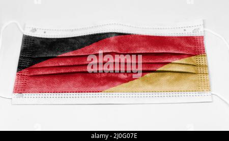 Chirurgische Maske mit der Nationalflagge Deutschlands gedruckt. Stockfoto