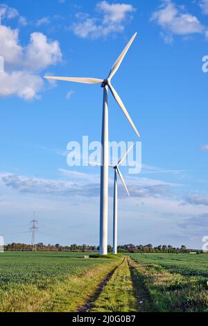 Windenergieanlagen und grüne Felder in Deutschland gesehen Stockfoto