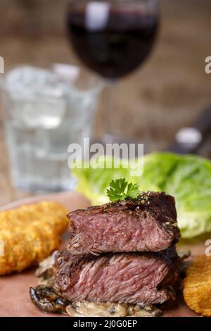 Steakscheiben mit Kroketten und Pilzen Stockfoto