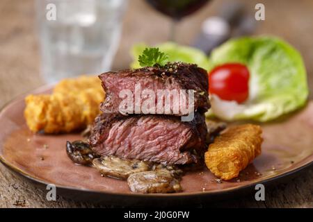 Steakscheiben mit Kroketten und Pilzen Stockfoto