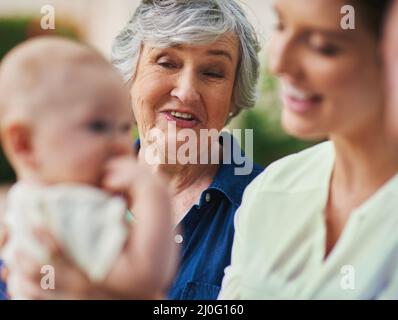 Hes einfach bezaubernd. Eine Aufnahme einer Familie aus drei Generationen, die sich im Freien aufhalte. Stockfoto