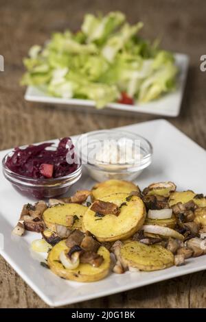 Bayerisches GrÃ¶stl mit Salat auf Holz Stockfoto