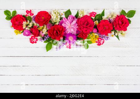 Blumenarrangement Rand von verschiedenen Feld und Garten Blumen von Rosen, Pfingstrosen und Jasmin auf einem weißen Holzhintergrund mit Stockfoto