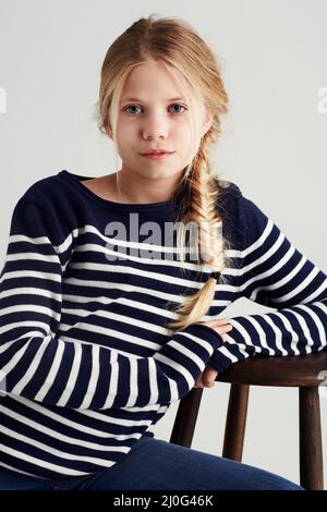 Shes bekam Taschen voller Haltung. Portrait eines niedlichen Mädchens, das im Studio auf einem Stuhl sitzt. Stockfoto