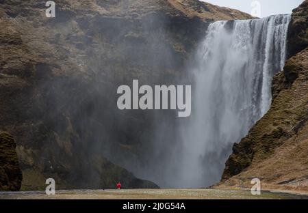 Touristen genießen den Skogafoss Wasserfall und Fluss in Island Stockfoto