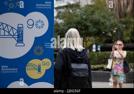 Sydney, Australien. 19. März 2022. Eine Frau macht am 19. März 2022 Fotos in der Nähe der Harbour Bridge in Sydney, Australien. Anlässlich des 90.. Jahres seit der Fertigstellung der Sydney Harbour Bridge gingen Sydneysider am Samstag in den Hafen, um der Brücke zu huldigen, die Generationen von Australiern miteinander verbunden und inspiriert hat. Quelle: Bai Xuefei/Xinhua/Alamy Live News Stockfoto