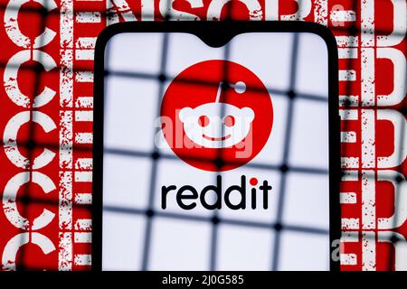 Reddit-Diskussionsplattform-Logo auf dem Smartphone-Bildschirm hinter den Balken im Hintergrund mit der Aufschrift zensiert. Stockfoto