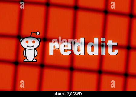 Das Logo der Reddit-Diskussionsplattform hinter Gittern. Das Konzept der Zensur und des Verbots von Reddit. Stockfoto