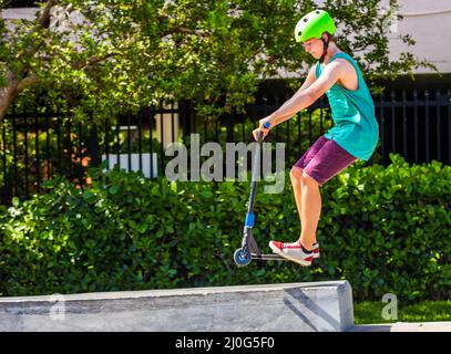 Teenager hat Spaß reiten sein push Roller an der Skate Park Stockfoto