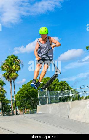 Teenager hat Spaß reiten sein push Roller an der Skate Park Stockfoto