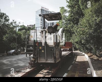 Russland, Sotschi 05.07.2020. Straßenfräsmaschine und LKW arbeiten auf der Straße in der Stadt Stockfoto