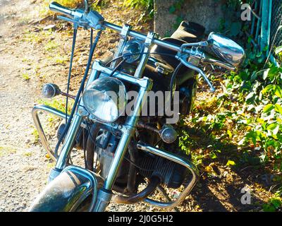 Ein Motorrad mit einem großen runden Scheinwerfer, der auf der Straße steht. Nahaufnahme Stockfoto