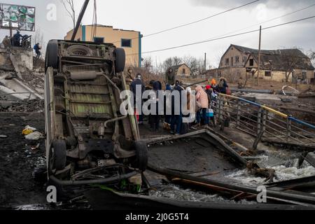 IRPIN, UKRAINE 03. März. Zivilisten überqueren die Brücke zwischen der Stadt Irpin und Kiew, die von ukrainischen Truppen gesprengt wurde, um einmarschierende russische Truppen zu blockieren, während der Krieg mit Russland am 03. März 2022 in Irpin, Ukraine, fortgesetzt wird. Russland begann am 24. Februar 2022 eine militärische Invasion der Ukraine, nachdem das russische parlament Verträge mit zwei abtrünnigen Regionen in der Ostukraine gebilligt hatte. Es ist der größte militärische Konflikt in Europa seit dem Zweiten Weltkrieg Stockfoto