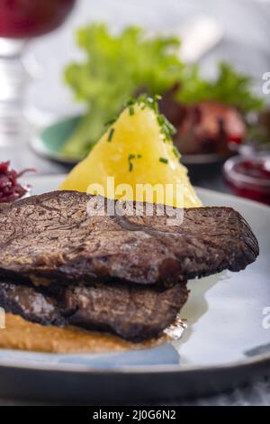 Sauerbraten auf einem Teller mit Knödeln Stockfoto