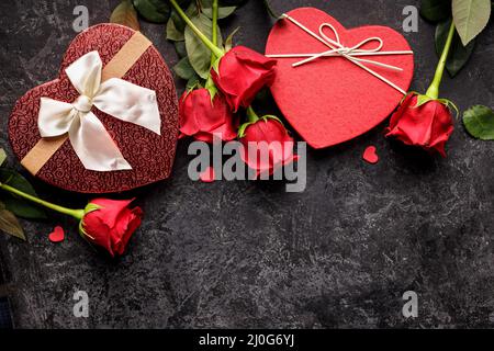 Feierkonzept für Valentinstag oder Geburtstag mit Herd Geformte Geschenkbox und Blumensträuße aus roten Rose Stockfoto