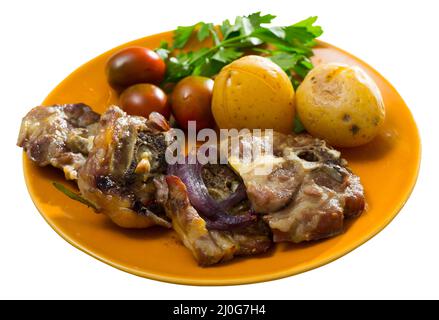 Lammkeule mit gebackenen Kartoffeln, Tomaten und Gemüse Stockfoto