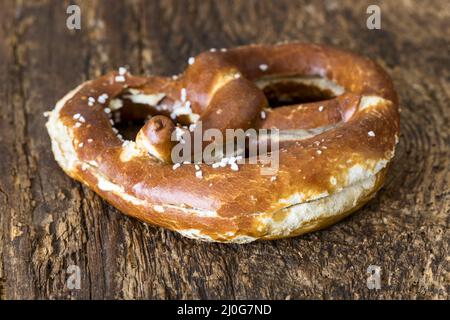 Bayerische Butterbrezel auf dunklem Holz Stockfoto