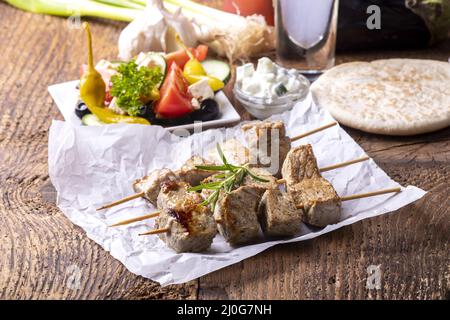 Griechischer Souvlaki auf dunklem Holz Stockfoto