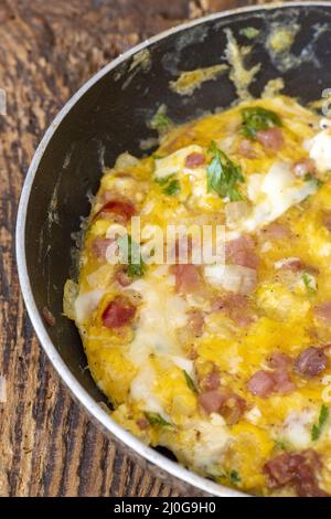 Rühreier in einer Pfanne auf Holz Stockfoto