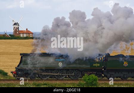 Dampflokomotive 34081 92 Squadron, vorbei an Weybourne Windmühle, North Norfolk Railway. Stockfoto